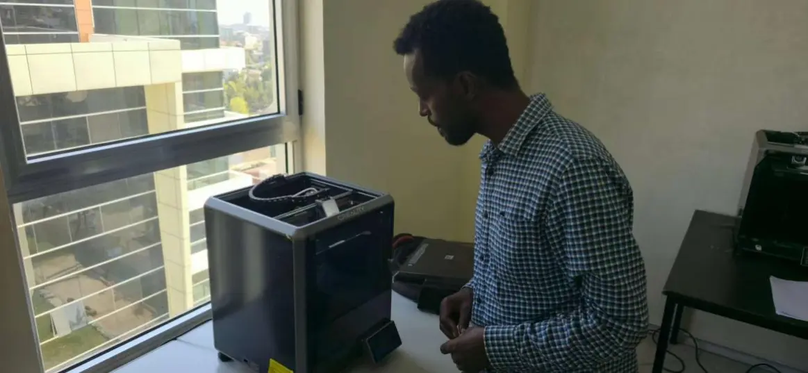 Ethiopian trainee operates industrial 3D printing equipment during practical coursework
